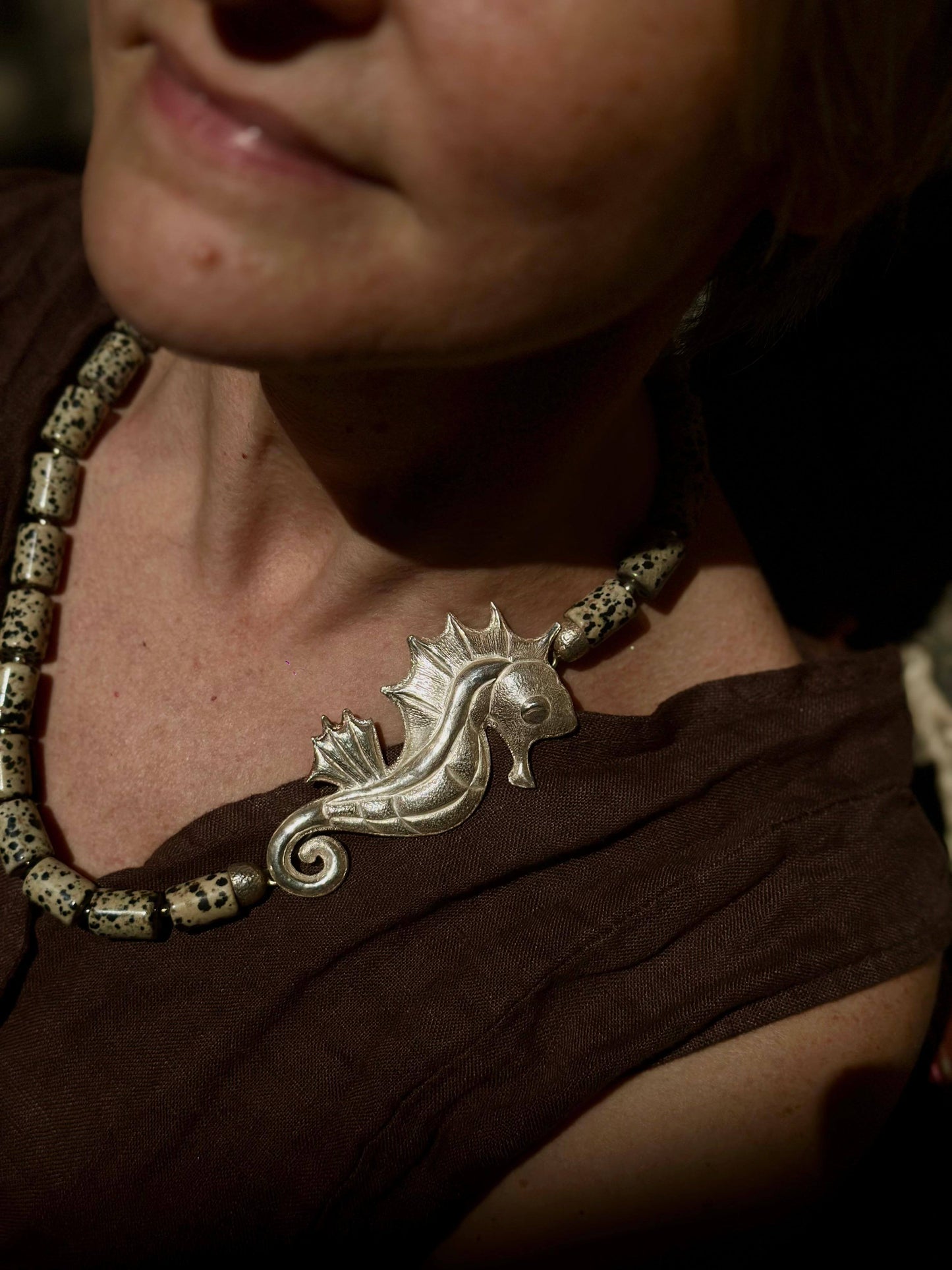 Collana in argento Seahorse indossata da donna con dettaglio di cavalluccio marino decorativo sul décolleté.